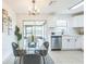 Bright dining area with modern chandelier, glass table, and serene view of screened lanai and backyard at 717 Fairmont Dr, Brandon, FL 33511