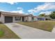 View of a single-story home featuring a gray garage door and concrete driveway with a well-manicured lawn at 717 Fairmont Dr, Brandon, FL 33511