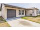 Single-story home with gray garage door, manicured lawn, and sidewalk leading to the front door at 717 Fairmont Dr, Brandon, FL 33511
