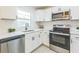 Updated kitchen with stainless steel appliances, white cabinets, and modern fixtures, ideal for cooking at 717 Fairmont Dr, Brandon, FL 33511