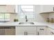 Stylish kitchen featuring white cabinets, granite countertops, and a stainless steel dishwasher with a window view at 717 Fairmont Dr, Brandon, FL 33511