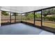 This screened porch has a blue floor, black frames, and a view of the backyard at 717 Fairmont Dr, Brandon, FL 33511