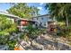 Well-manicured backyard garden featuring a screened porch, stone pathway, and lush greenery at 7427 4Th N Ave, St Petersburg, FL 33710