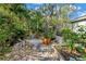 Landscaped backyard featuring various plants, trees, a stone pathway, and shell accents at 7427 4Th N Ave, St Petersburg, FL 33710