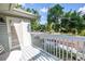 Balcony features neutral railings, a small table and chairs, and an exterior view of trees at 7427 4Th N Ave, St Petersburg, FL 33710