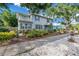 Charming two-story home featuring a second story balcony, mature trees, and decorative landscaping at 7427 4Th N Ave, St Petersburg, FL 33710