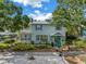 Charming two-story home with light green siding, lush landscaping, and a cozy second story balcony at 7427 4Th N Ave, St Petersburg, FL 33710