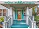 Inviting front porch with decorative trim, turquoise accents, and a wood door with glass panes at 7427 4Th N Ave, St Petersburg, FL 33710