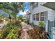 Beautiful landscaping featuring a brick path leading to the side of the home and mature tropical plants at 7427 4Th N Ave, St Petersburg, FL 33710