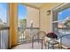 Cozy balcony with chairs and potted flowers overlooking a view of palm trees and adjacent buildings at 10764 70Th Ave # 6210, Seminole, FL 33772