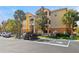 Three-story building with a modern facade, balconies, and EV charging stations surrounded by manicured landscaping at 10764 70Th Ave # 6210, Seminole, FL 33772