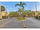 Secure gated entrance providing access to the community, enhanced by landscaping, and palm trees at 10764 70Th Ave # 6210, Seminole, FL 33772