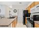 Kitchen featuring black appliances, wood cabinets, and view into the dining room at 10764 70Th Ave # 6210, Seminole, FL 33772