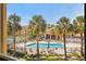 Community pool surrounded by palm trees, lounge chairs, and a clubhouse offering a resort-like experience at 10764 70Th Ave # 6210, Seminole, FL 33772
