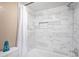 Tiled shower with a toiletry shelf and glass door provides modern convenience in this bathroom space at 1125 Pinellas Bayway S # 103, Tierra Verde, FL 33715
