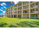 Multi-story condo building with spacious balconies, surrounded by lush green lawns, and serene landscaping at 1125 Pinellas Bayway S # 103, Tierra Verde, FL 33715
