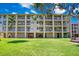 Multi-story condo building featuring spacious balconies, lush green lawns, and convenient ground-level storage at 1125 Pinellas Bayway S # 103, Tierra Verde, FL 33715