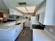 Modern kitchen featuring sleek white cabinets, stainless steel appliances, quartz countertops, and a stylish breakfast bar at 1125 Pinellas Bayway S # 103, Tierra Verde, FL 33715
