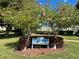 The Old Island Inn property sign amidst blooming trees and lush greenery, offering curb appeal at 1125 Pinellas Bayway S # 103, Tierra Verde, FL 33715