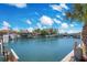 Scenic waterfront view featuring boats docked along the canal under a bright blue, cloudy sky at 1125 Pinellas Bayway S # 103, Tierra Verde, FL 33715