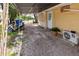 Side exterior view of a yellow home with a covered driveway, offering parking and shelter from the elements at 1144 7Th Nw St, Largo, FL 33770