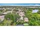 Beautiful aerial view of a home with a pool, lush landscaping and close proximity to a lake and local amenities at 120 Colony South Dr, Tarpon Springs, FL 34689