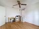 Bedroom with hardwood floors featuring a study desk, storage, and a ceiling fan at 120 Colony South Dr, Tarpon Springs, FL 34689