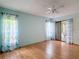 Bedroom with wood laminate flooring, access to a covered patio through sliding glass doors, and a ceiling fan at 120 Colony South Dr, Tarpon Springs, FL 34689