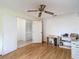 Bedroom featuring hardwood floors, ceiling fan, and a study desk next to the closet at 120 Colony South Dr, Tarpon Springs, FL 34689