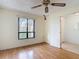 Bright bedroom featuring hard wood floors, a ceiling fan, and a view outside at 120 Colony South Dr, Tarpon Springs, FL 34689