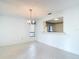 Light dining room with tiled floors, chandelier, and view to the kitchen through an opening in the wall at 120 Colony South Dr, Tarpon Springs, FL 34689