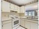 Traditional kitchen featuring white cabinetry, appliances, and neutral colored surfaces at 120 Colony South Dr, Tarpon Springs, FL 34689