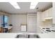 Bright kitchen featuring white appliances and cabinetry, decorative wallpaper, and a breakfast nook at 120 Colony South Dr, Tarpon Springs, FL 34689