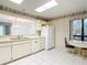 Bright kitchen with white appliances, tile flooring, and a seamless pass-through to the dining area at 120 Colony South Dr, Tarpon Springs, FL 34689