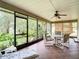 A screened lanai boasts tile flooring, garden views, and a table with chairs for outdoor seating at 120 Colony South Dr, Tarpon Springs, FL 34689