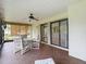 A screened lanai features tile flooring, a ceiling fan, and patio seating with outside access at 120 Colony South Dr, Tarpon Springs, FL 34689