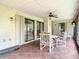 A screened lanai features tile floors, a ceiling fan, and a table with four chairs for outdoor dining at 120 Colony South Dr, Tarpon Springs, FL 34689