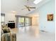 Open living room with vaulted ceilings, ceiling fan, and sliding glass doors to patio at 120 Colony South Dr, Tarpon Springs, FL 34689