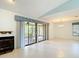 Open living space with vaulted ceilings, fireplace, and sliding door access to the lanai at 120 Colony South Dr, Tarpon Springs, FL 34689