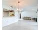 Bright living room with tiled floor, large opening to the kitchen, and view to the rear of the property at 120 Colony South Dr, Tarpon Springs, FL 34689