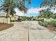 Street view of a community featuring well-maintained landscaping, mature trees and multiple parked cars at 120 Colony South Dr, Tarpon Springs, FL 34689