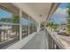 View down condo exterior corridor with view of parking and mature trees at 1221 Drew St # E12, Clearwater, FL 33755