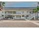 Condo exterior with stairs, landscaping, and awning-covered patio furniture offering relaxed outdoor living at 1221 Drew St # E12, Clearwater, FL 33755