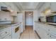 Galley kitchen boasting white cabinetry, granite countertops, and stainless steel microwave at 1221 Drew St # E12, Clearwater, FL 33755