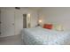 Bright bedroom featuring patterned bedding and an ensuite bathroom at 1241 S Martin Luther King Jr Ave # 302, Clearwater, FL 33756