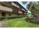 Multi-story building with brown trim and balconies surrounded by lush green landscaping at 1241 S Martin Luther King Jr Ave # 302, Clearwater, FL 33756