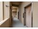 Neutral-toned hallway leads to a wood-paneled elevator and doorway at 1241 S Martin Luther King Jr Ave # 302, Clearwater, FL 33756