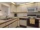 The kitchen includes a double sink, microwave, and white cabinetry at 1241 S Martin Luther King Jr Ave # 302, Clearwater, FL 33756