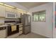 Bright kitchen with white cabinetry, tile floors, and stainless steel refrigerator at 1241 S Martin Luther King Jr Ave # 302, Clearwater, FL 33756