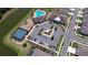 Aerial view of community amenities, including a pool, playground, tennis courts, and parking area near a lake at 12902 Brookside Moss Dr, Riverview, FL 33579